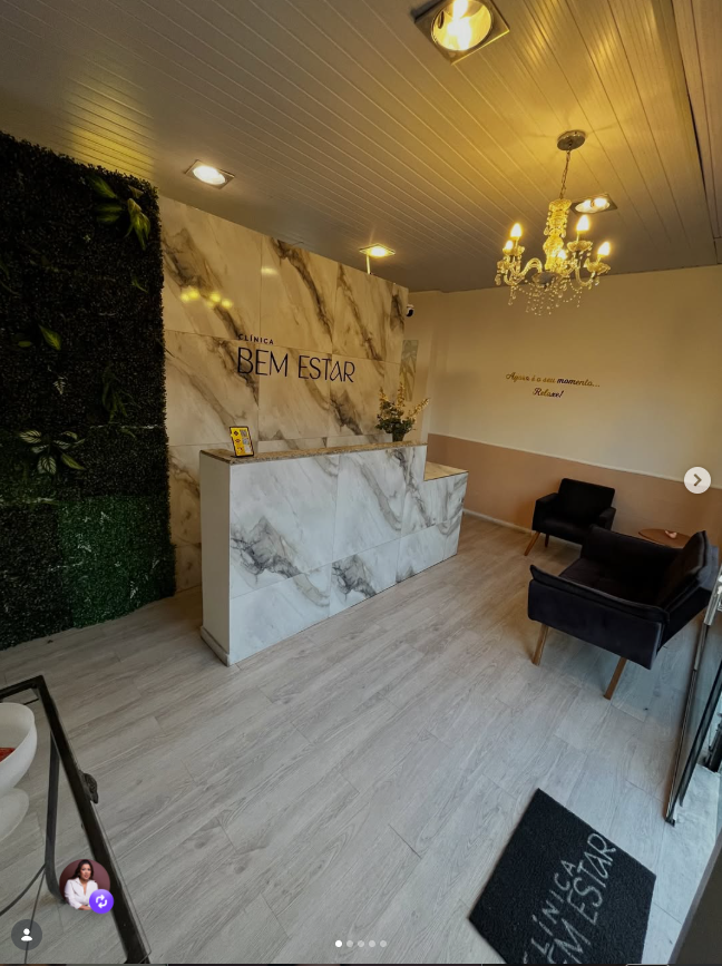 Recepção da Clínica Bem Estar, com parede de mármore e iluminação aconchegante